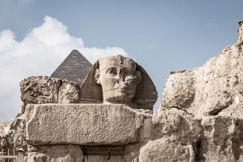 La Grande Sfinge di Giza tra i blocchi di pietra, con la piramide di Chefren sullo sfondo, Egitto.