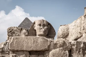 La Grande Sfinge di Giza tra i blocchi di pietra, con la piramide di Chefren sullo sfondo, Egitto.