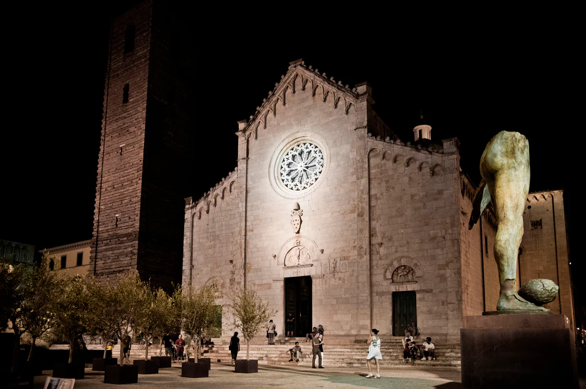 Duomo di San Martino a Pietrasanta di notte, con una scultura monumentale di Igor Mitoraj